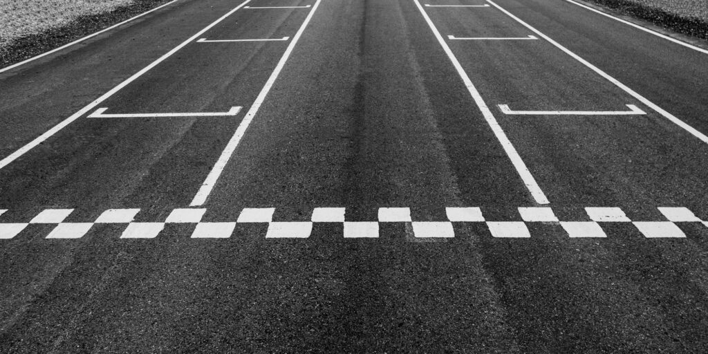 Aerial view abstract asphalt black Start and Finish grid line for race car in circuit texture.