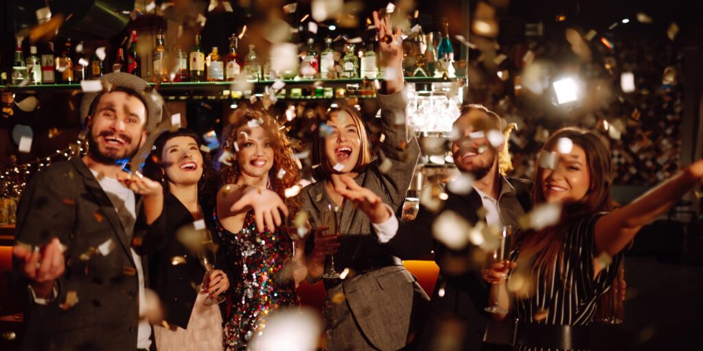 Happy friends throwing confetti and jumping while enjoying party Confetti is fun. Party, celebration