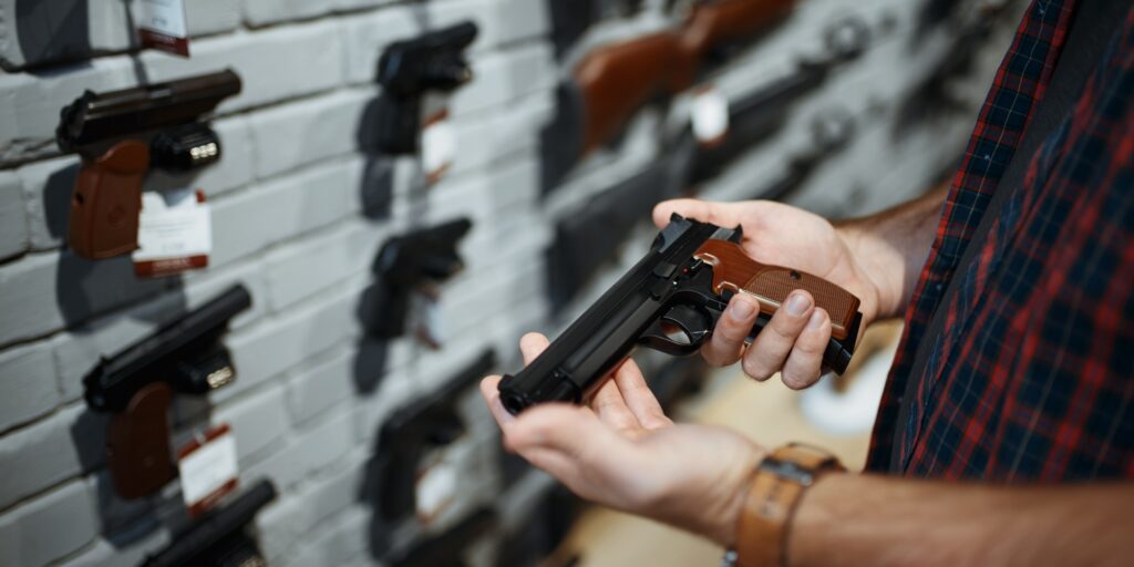 Man holds handgun in gun shop