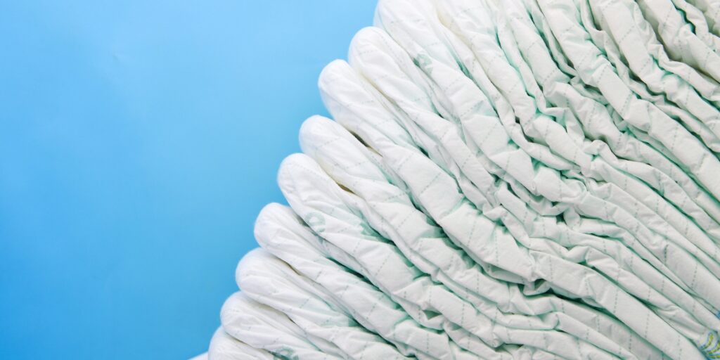 stack of baby diaper on blue background with copy space