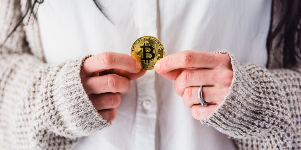 Woman's hands holding a bitcoin coin.